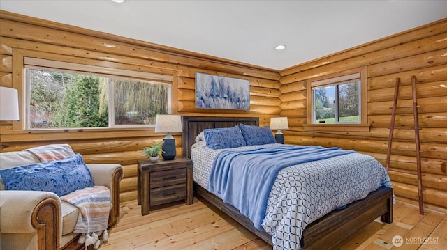 bedroom featuring rustic walls, light wood-style flooring, and recessed lighting