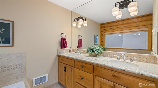 bathroom with double vanity, visible vents, and a sink