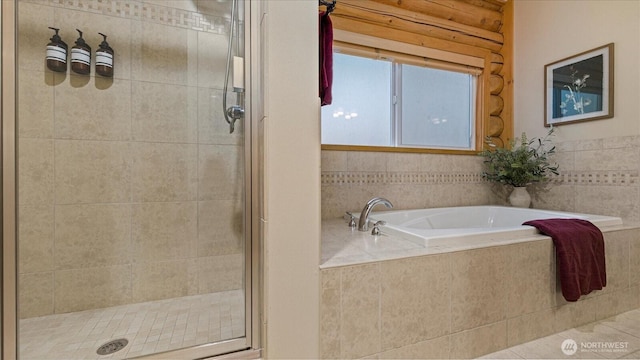 full bathroom featuring a bath and a stall shower