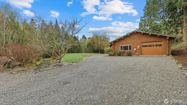 view of property exterior featuring a garage, gravel driveway, and log exterior