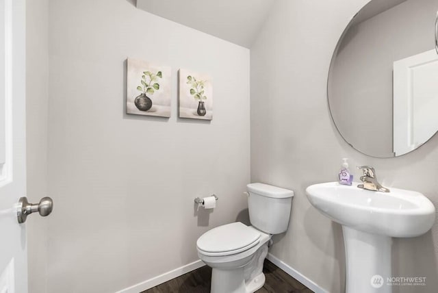 bathroom with a sink, wood finished floors, toilet, and baseboards