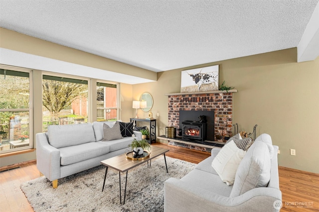 living room with visible vents, a textured ceiling, and wood finished floors