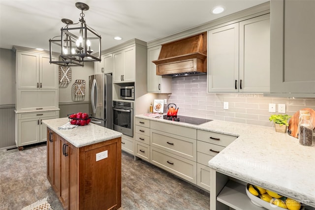 kitchen with light stone counters, premium range hood, a kitchen island, appliances with stainless steel finishes, and wainscoting