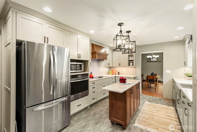 kitchen featuring premium range hood, stainless steel appliances, a notable chandelier, tasteful backsplash, and a center island