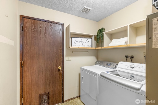 laundry area featuring washer and dryer, laundry area, visible vents, and a textured ceiling