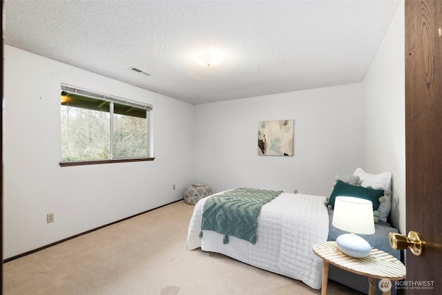 bedroom with carpet flooring, baseboards, visible vents, and a textured ceiling