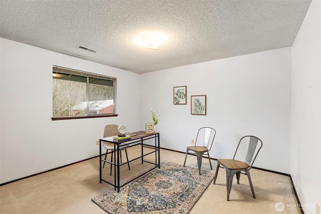 carpeted office featuring baseboards, visible vents, and a textured ceiling