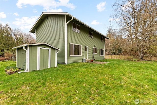 back of property featuring an outbuilding, a lawn, and a storage unit