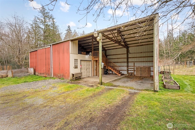 view of pole building featuring a carport, a lawn, and driveway