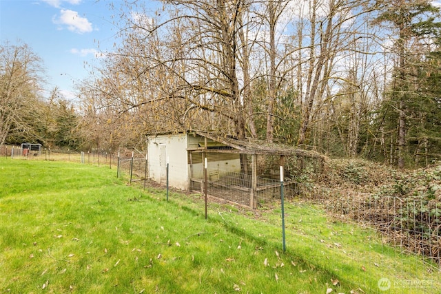 view of yard with an outbuilding, fence, and exterior structure