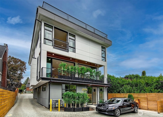 modern home featuring fence and stucco siding