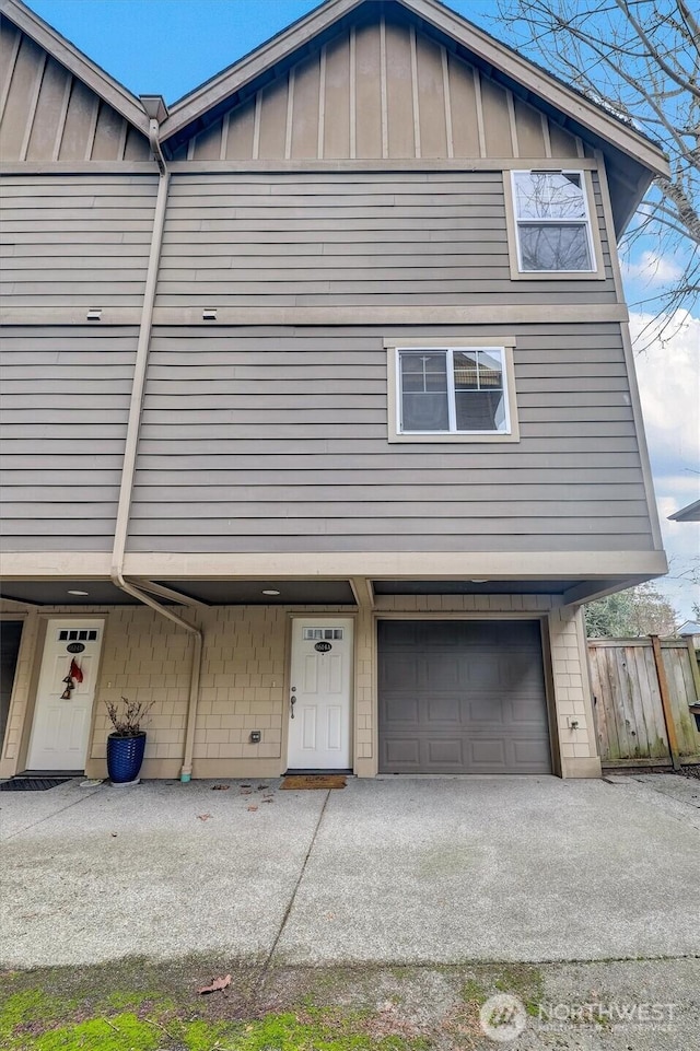 view of front of house with an attached garage, fence, and board and batten siding