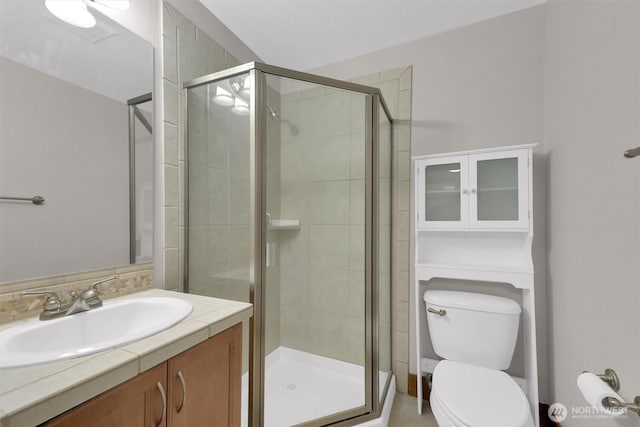 full bathroom featuring toilet, a shower stall, and vanity