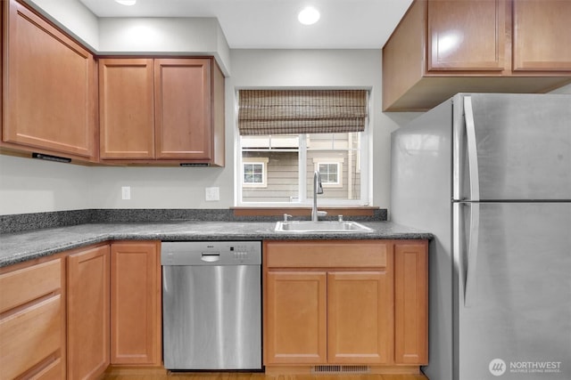 kitchen with visible vents, freestanding refrigerator, stainless steel dishwasher, a sink, and recessed lighting