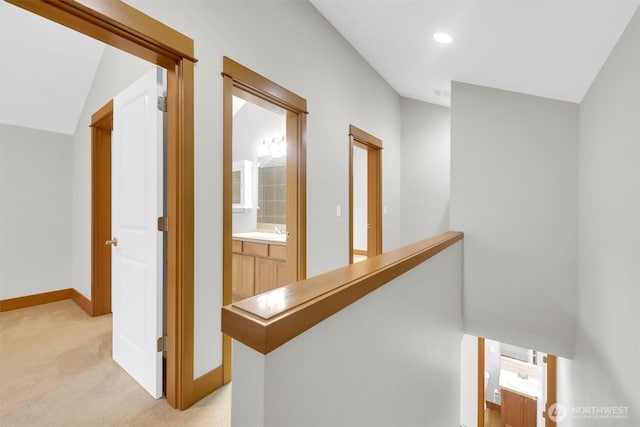 hallway with an upstairs landing, recessed lighting, light carpet, and baseboards