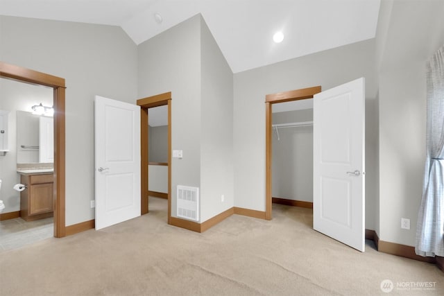 unfurnished bedroom featuring vaulted ceiling, baseboards, visible vents, and light colored carpet