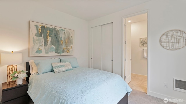 bedroom featuring baseboards, a closet, and light colored carpet