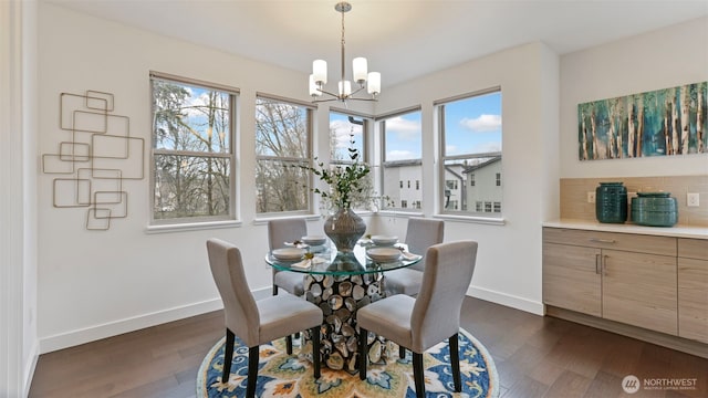 dining area with dark wood-type flooring, a wealth of natural light, and baseboards