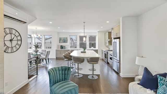 interior space with high end appliances, a kitchen breakfast bar, a center island, light countertops, and a wall mounted AC