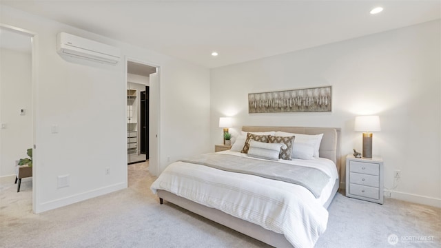 bedroom with recessed lighting, light carpet, baseboards, a wall mounted AC, and a walk in closet