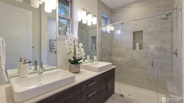 bathroom with double vanity, a sink, and a shower stall