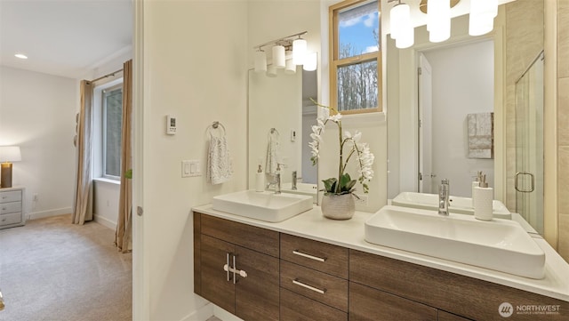 full bath featuring double vanity, a stall shower, and a sink