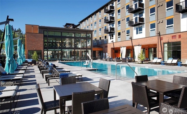 pool featuring a patio area and outdoor dining area