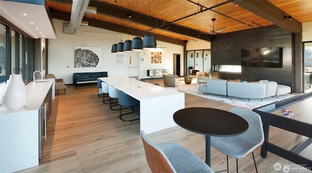 kitchen with wooden ceiling, open floor plan, beam ceiling, and light wood finished floors