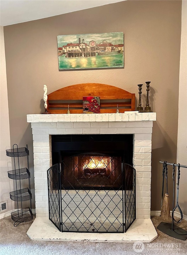 details featuring visible vents, a fireplace, baseboards, and carpet flooring