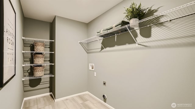 clothes washing area featuring laundry area, baseboards, washer hookup, and electric dryer hookup