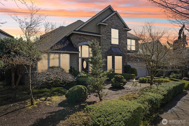 view of front of house with stone siding and a shingled roof