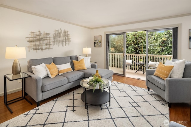 living room with crown molding, light wood-style flooring, and baseboards