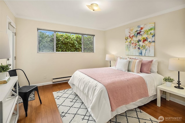 bedroom featuring baseboards, baseboard heating, wood finished floors, and crown molding