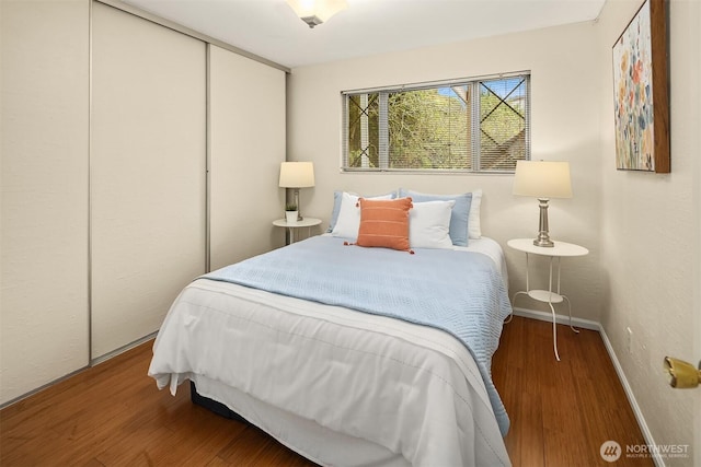 bedroom featuring a closet, baseboards, and wood finished floors