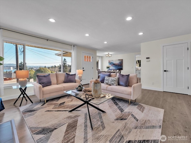 living area featuring baseboards, wood finished floors, and recessed lighting