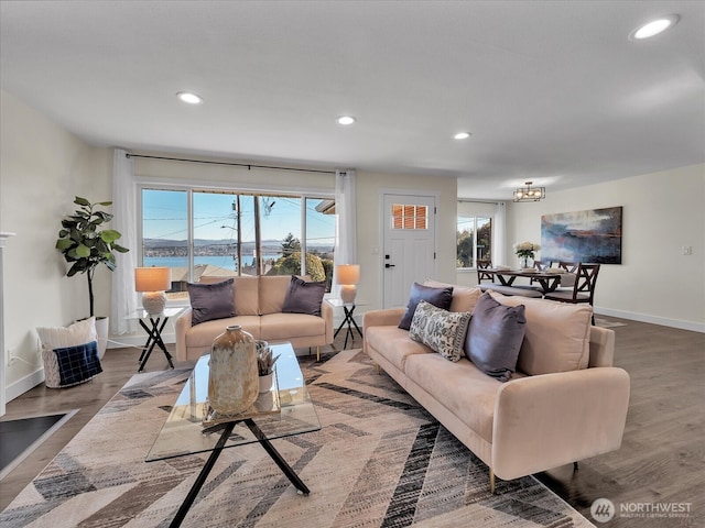 living area featuring baseboards, wood finished floors, and recessed lighting