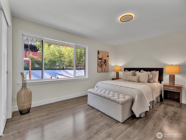 bedroom with wood finished floors and baseboards