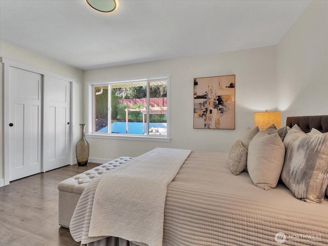 bedroom featuring a closet, wood finished floors, and baseboards