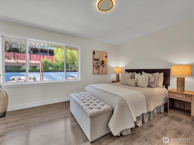 bedroom with wood finished floors and baseboards