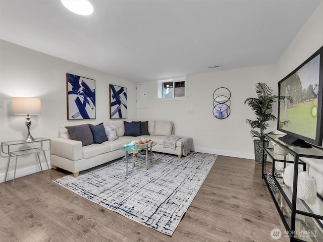 living area with visible vents, baseboards, and wood finished floors