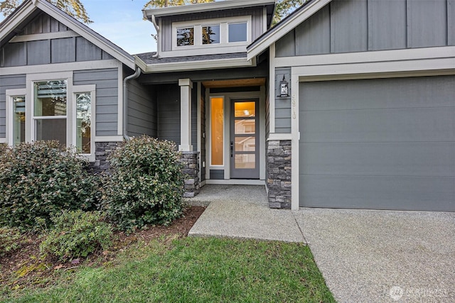 view of exterior entry featuring board and batten siding, stone siding, and a garage