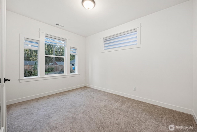 carpeted empty room with baseboards and visible vents