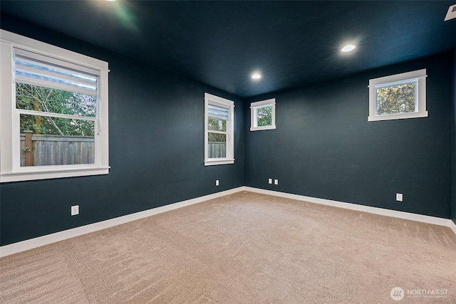 carpeted empty room featuring recessed lighting, plenty of natural light, and baseboards