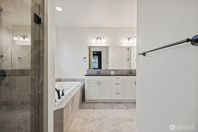 bathroom with double vanity, a stall shower, a bath, marble finish floor, and a sink