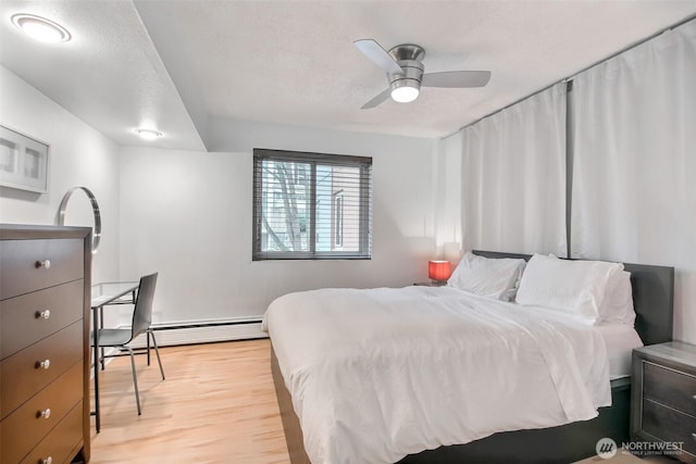 bedroom with a textured ceiling, light wood-type flooring, a ceiling fan, and a baseboard radiator