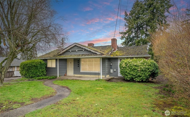 view of front of property featuring a yard and a chimney