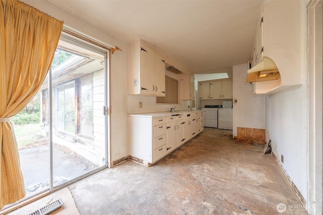 kitchen with unfinished concrete flooring, visible vents, washing machine and dryer, and light countertops