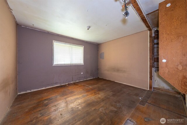 empty room featuring visible vents and hardwood / wood-style floors