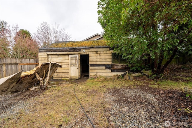 view of outbuilding featuring fence