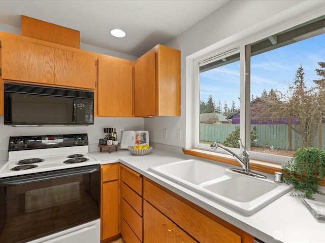 kitchen with electric range, recessed lighting, a sink, light countertops, and black microwave